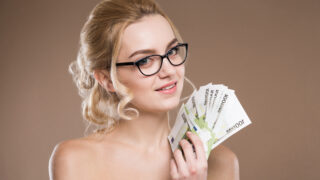 portrait of a girl in glasses with money in hand